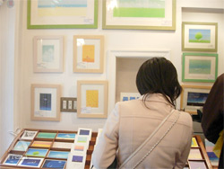 地雷ではなく花をください：絵画やポストカードを熱心に選ぶ訪問客