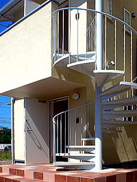 螺旋階段と玄関ステップのタイルがお洒落な外観。